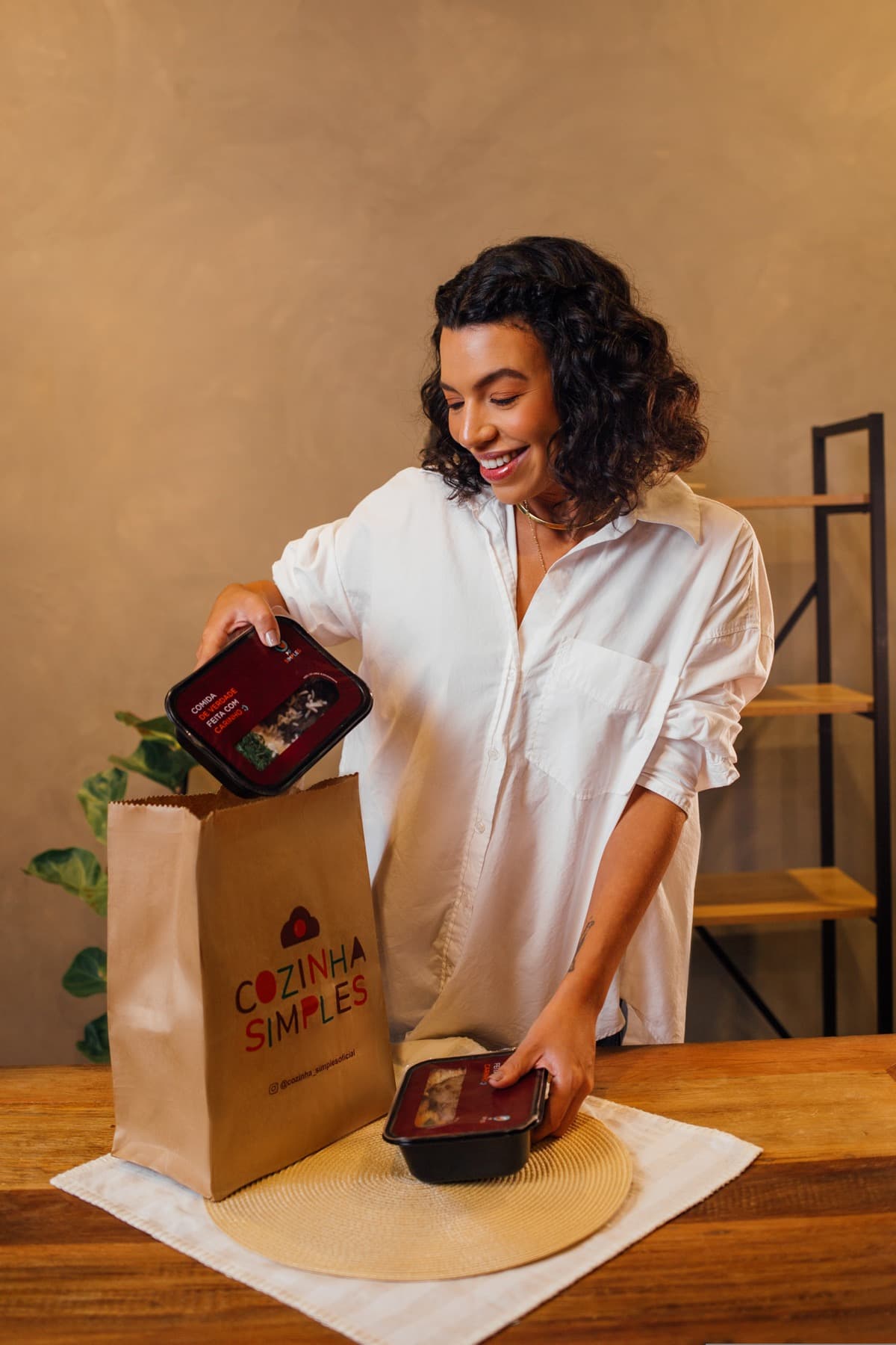 Cliente recebendo refeições e sacola da Cozinha Simples